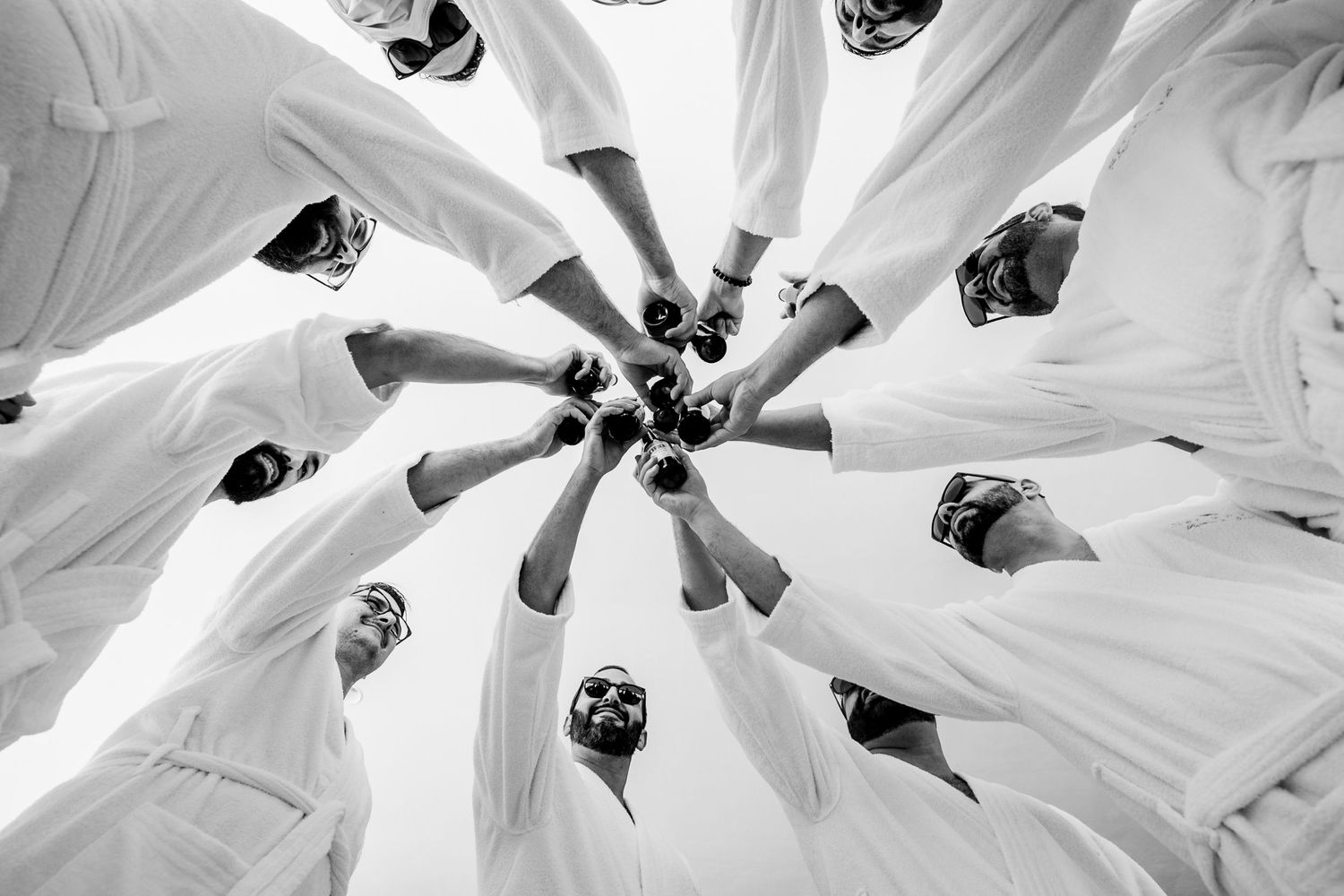Creative overhead shot of wedding party forming a circle in white dresses.