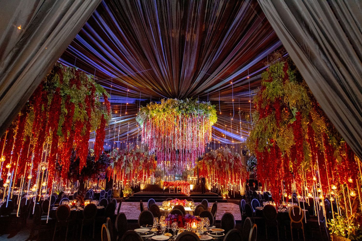 Stunning indoor event space with dramatic red and gold lighting effects creating an enchanting atmosphere.