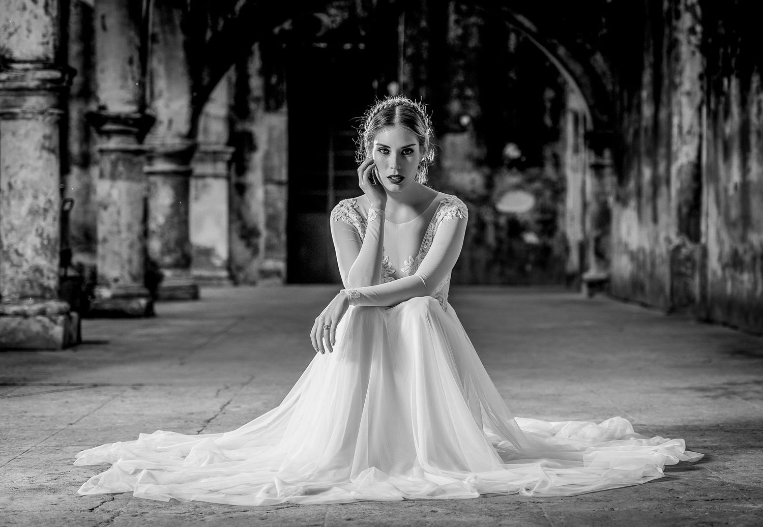 Elegant black and white bridal portrait in historic colonnade setting.