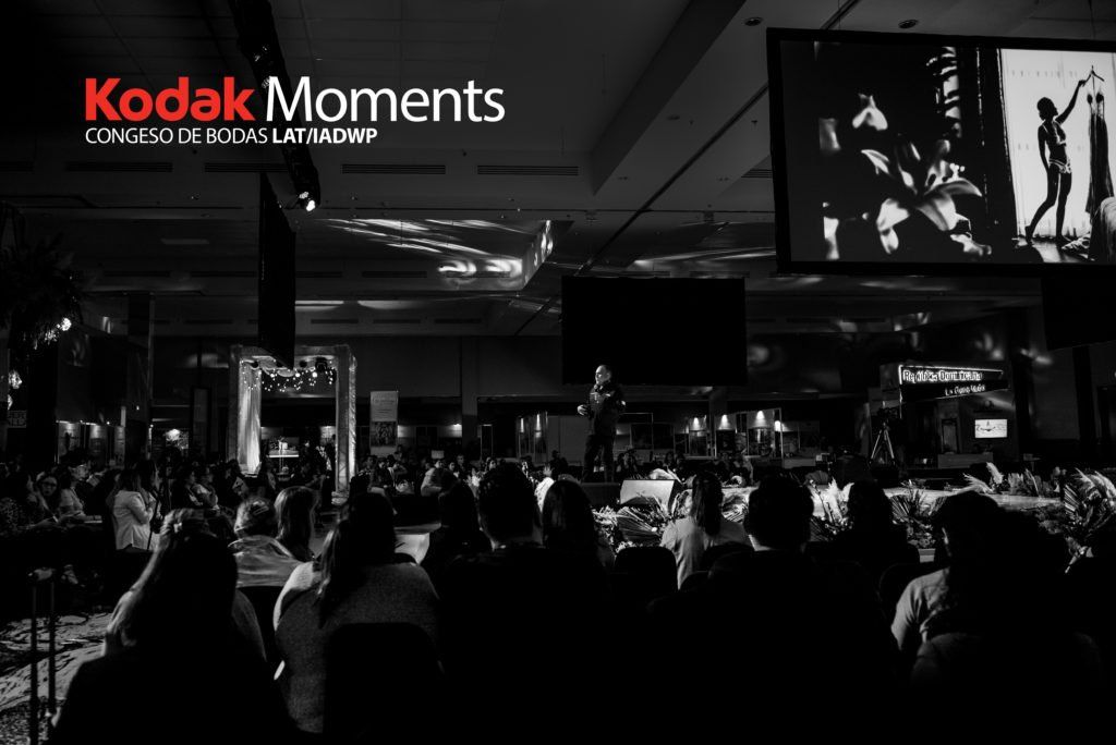 Dark venue with Kodak branding and event signage visible.