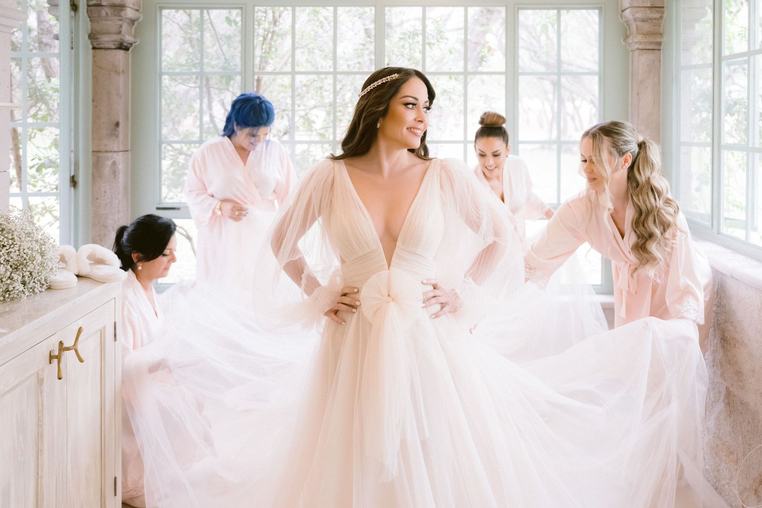 Ethereal scene of flowing pink and white bridal robes in sunlit room.