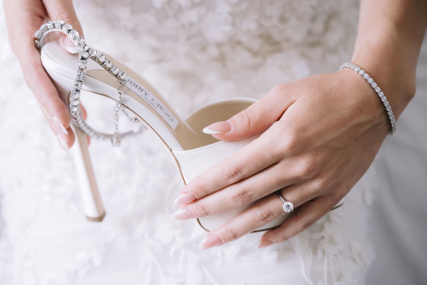 Close up details of delicate bridal jewelry and accessories on white background.
