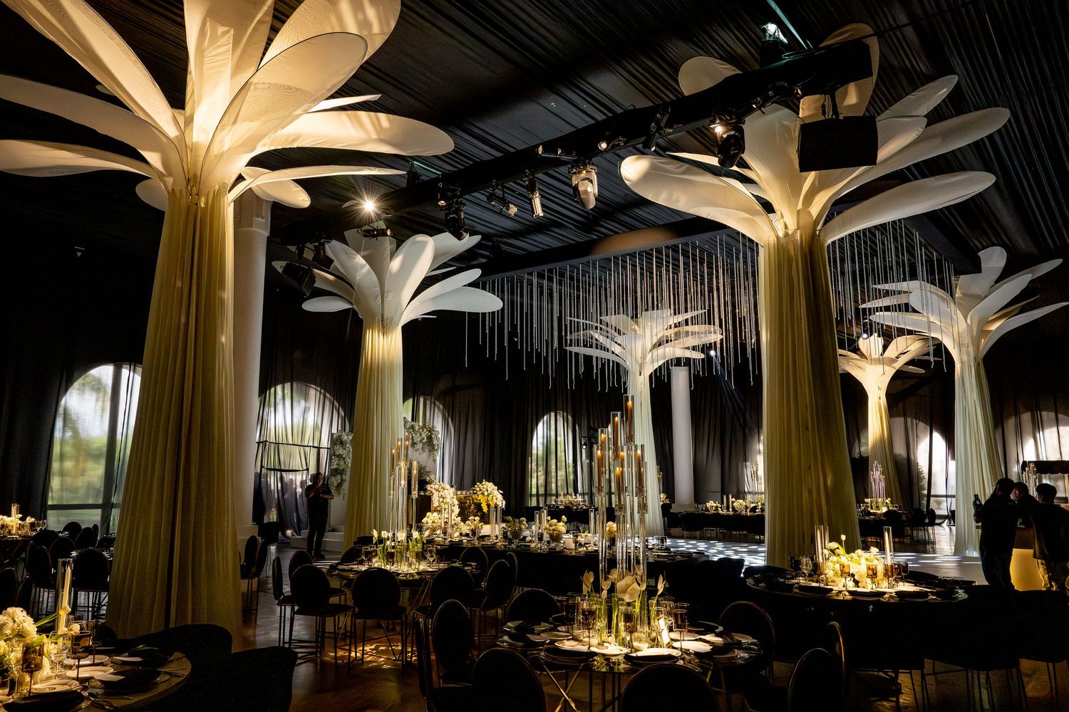Modern reception venue with dramatic palm-inspired golden ceiling installations and mood lighting.