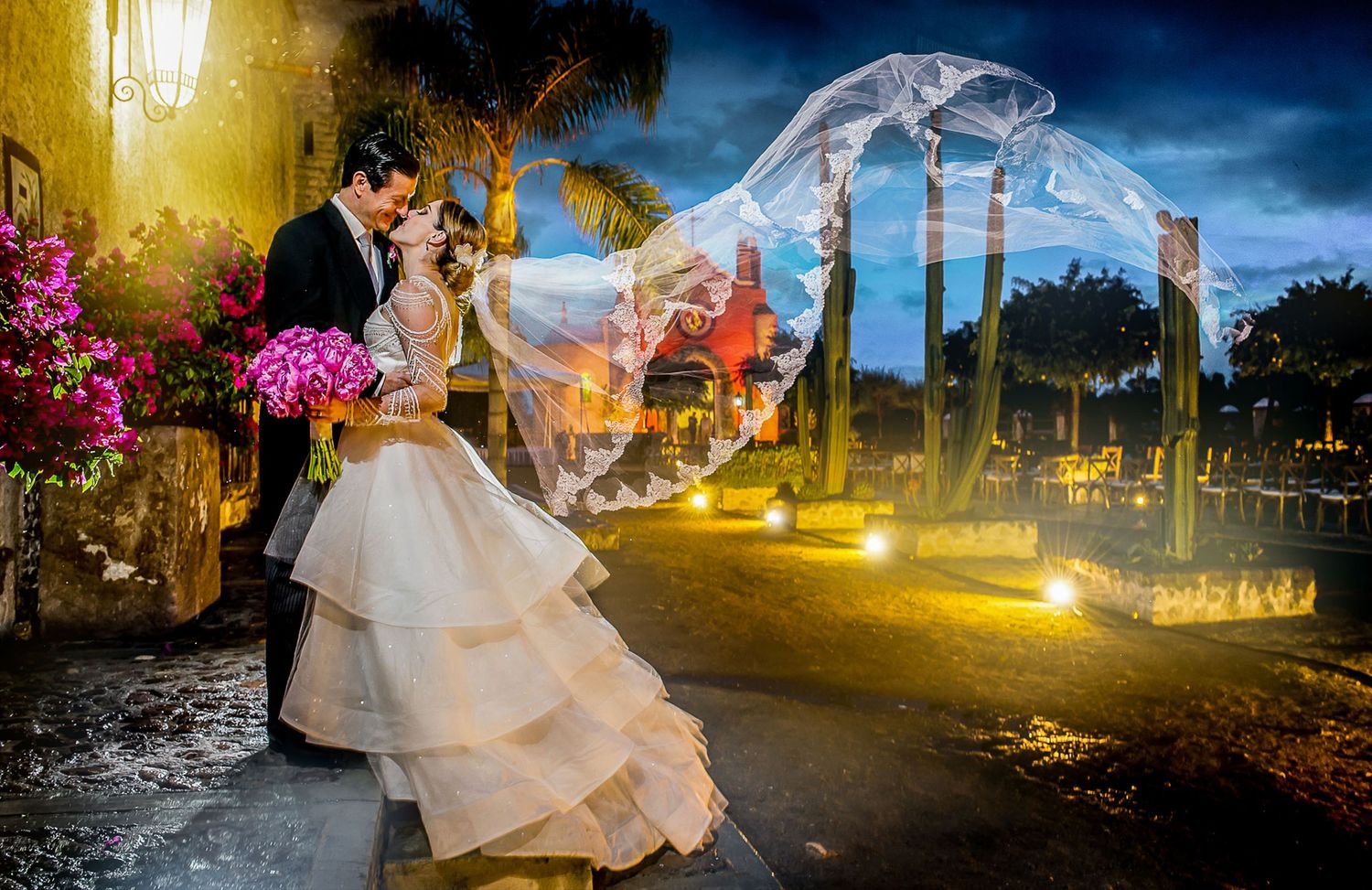 Evening wedding portraits with dramatic outdoor lighting and garden scenery.