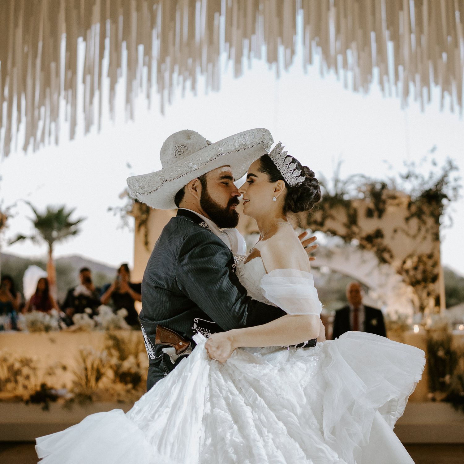 Wedding couple shares romantic dance moment under rustic floral ceiling decorations.