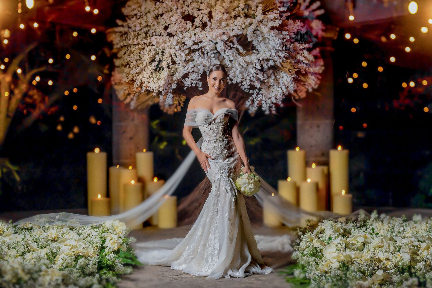 Glamorous fitted wedding dress photographed at night with illuminated cherry blossoms and candles.