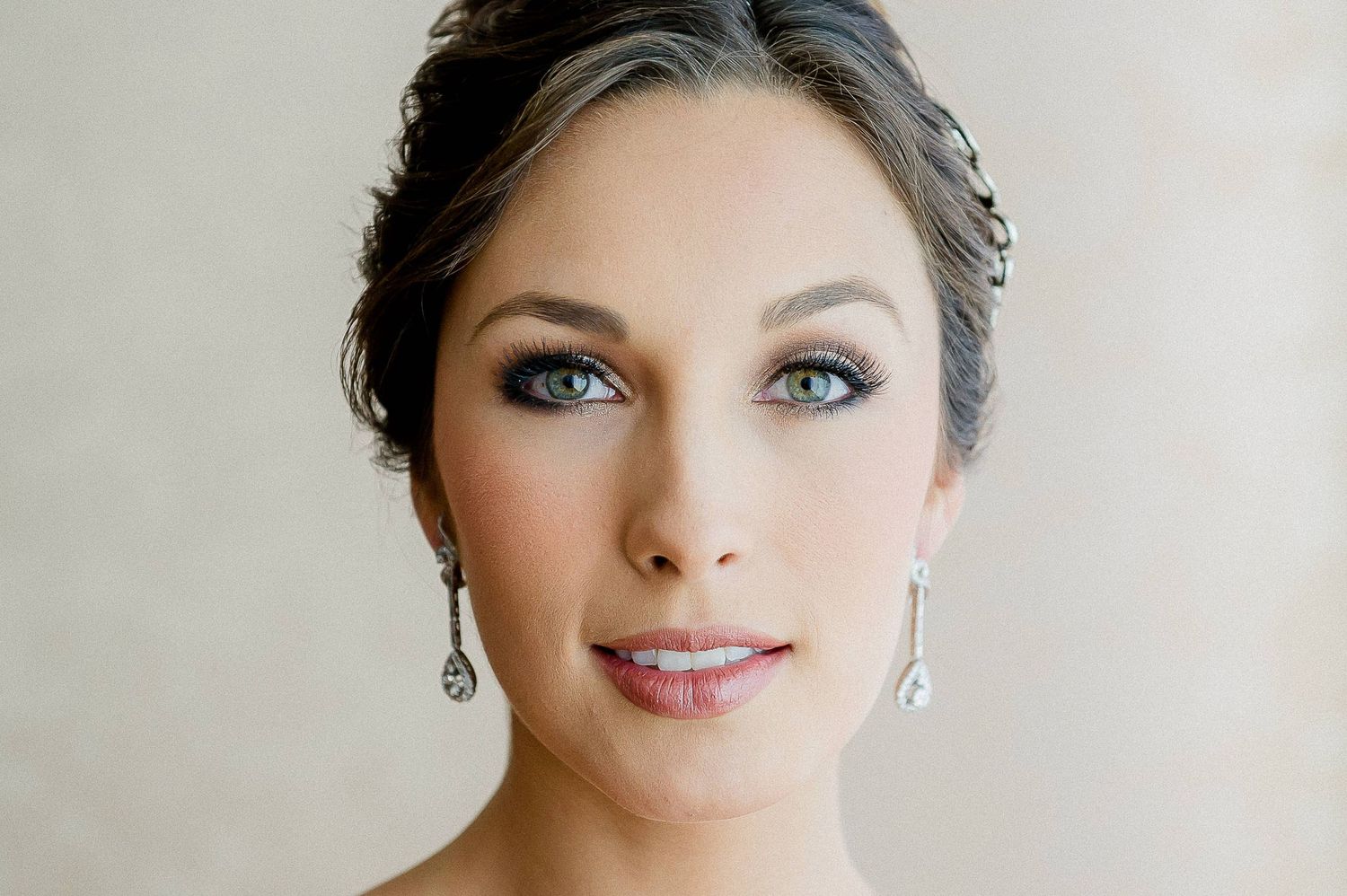 An elegant bridal portrait showcasing classic makeup and sparkling drop earrings.
