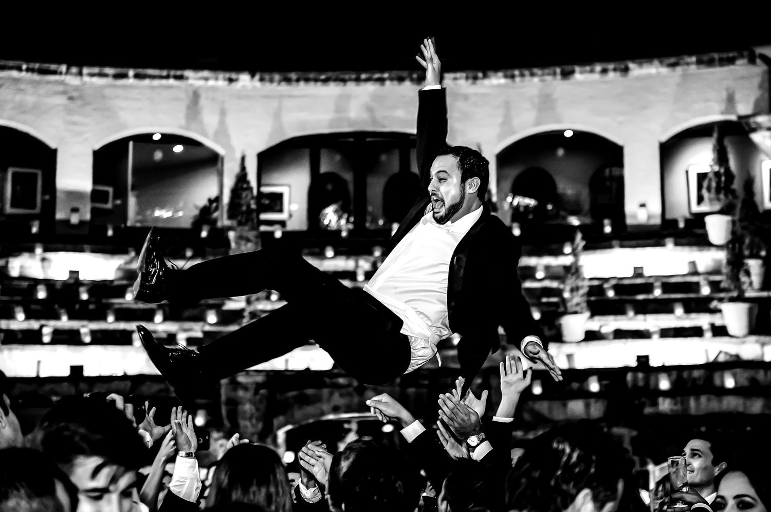 Black and white photo of celebratory moment at wedding reception.