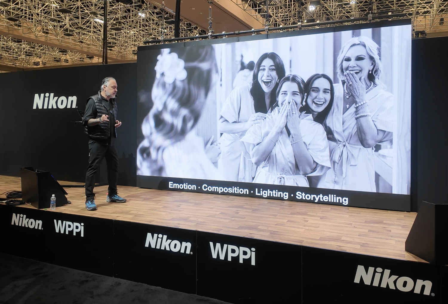 Large display screens showing black and white photography at a Nikon exhibition space.