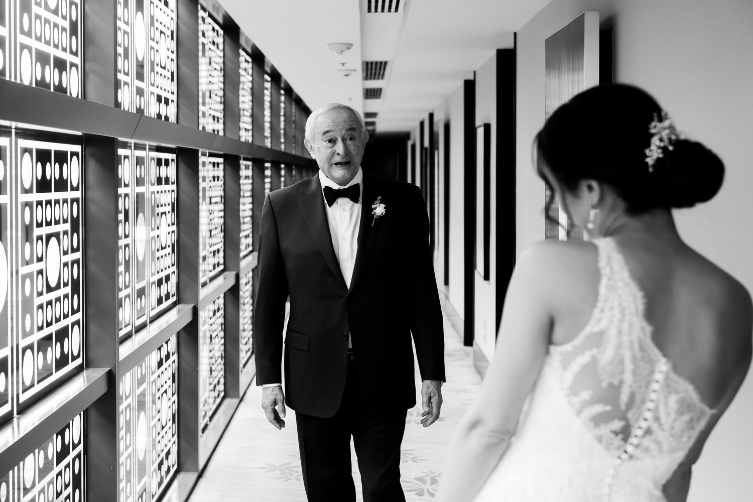 Black and white wedding photo collage showing couple walking down hallway and romantic moments in a modern venue.