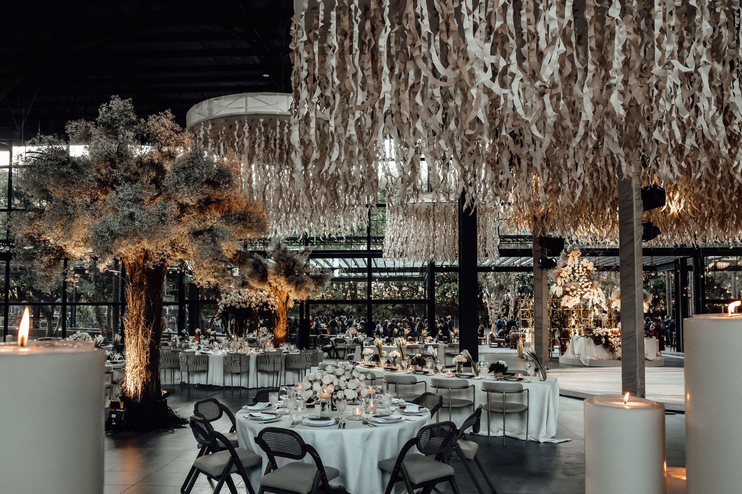 Contemporary wedding venue with dramatic lighting and suspended white fabric creating an elegant atmosphere.