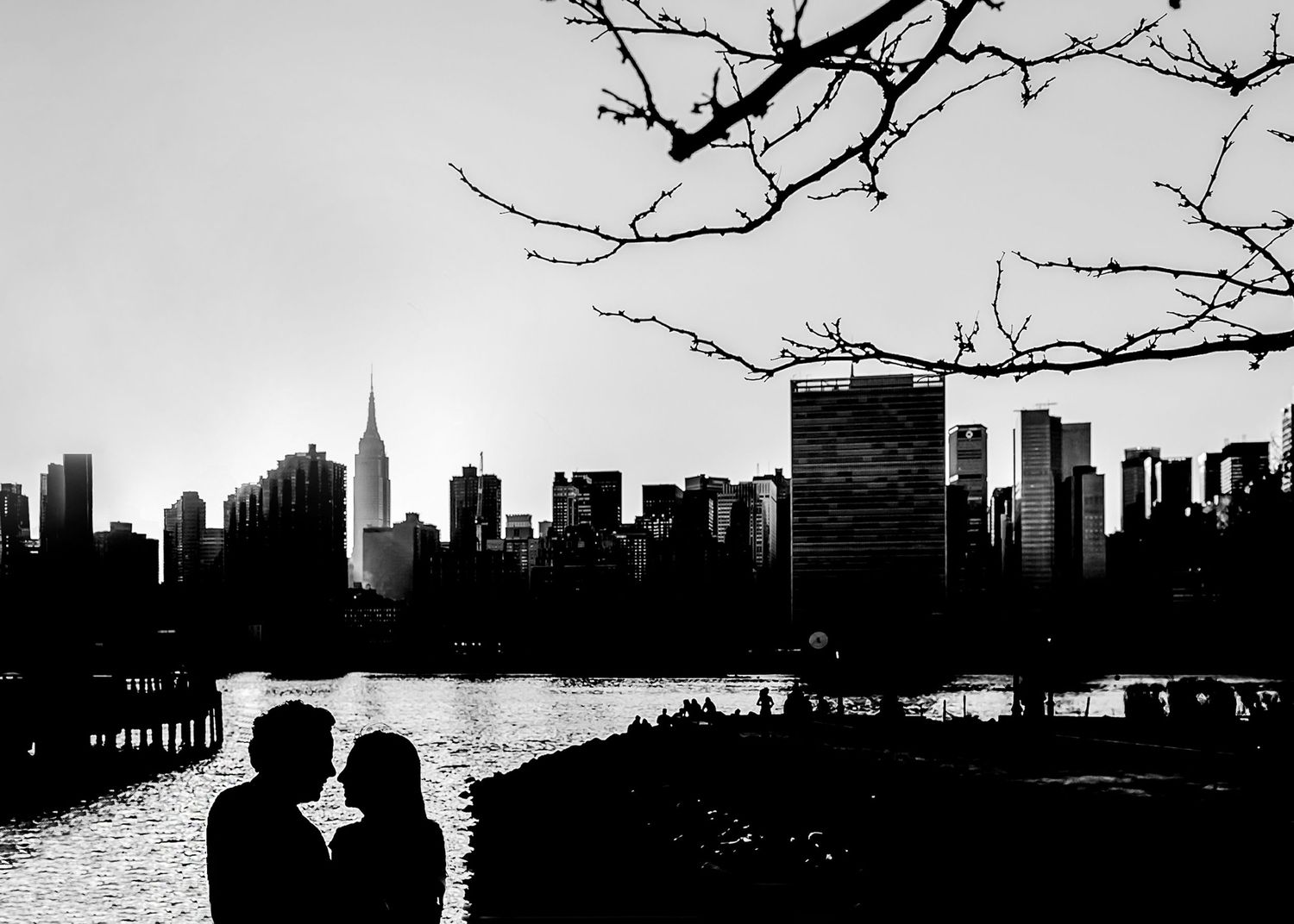 Dramatic black and white cityscape silhouettes showing urban skyline against bright sky.