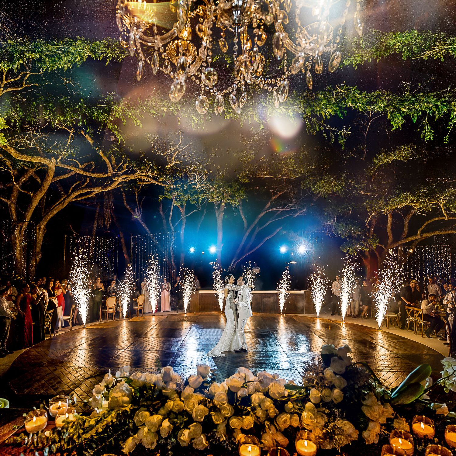 Outdoor wedding celebration with fountain fireworks creating a dramatic nighttime display.