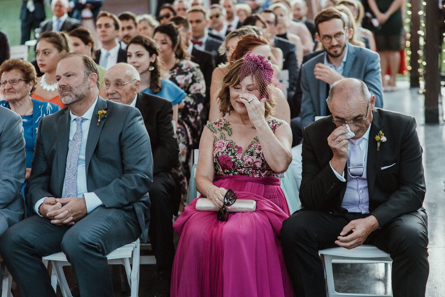 Wedding guests showing emotional reactions during ceremony.