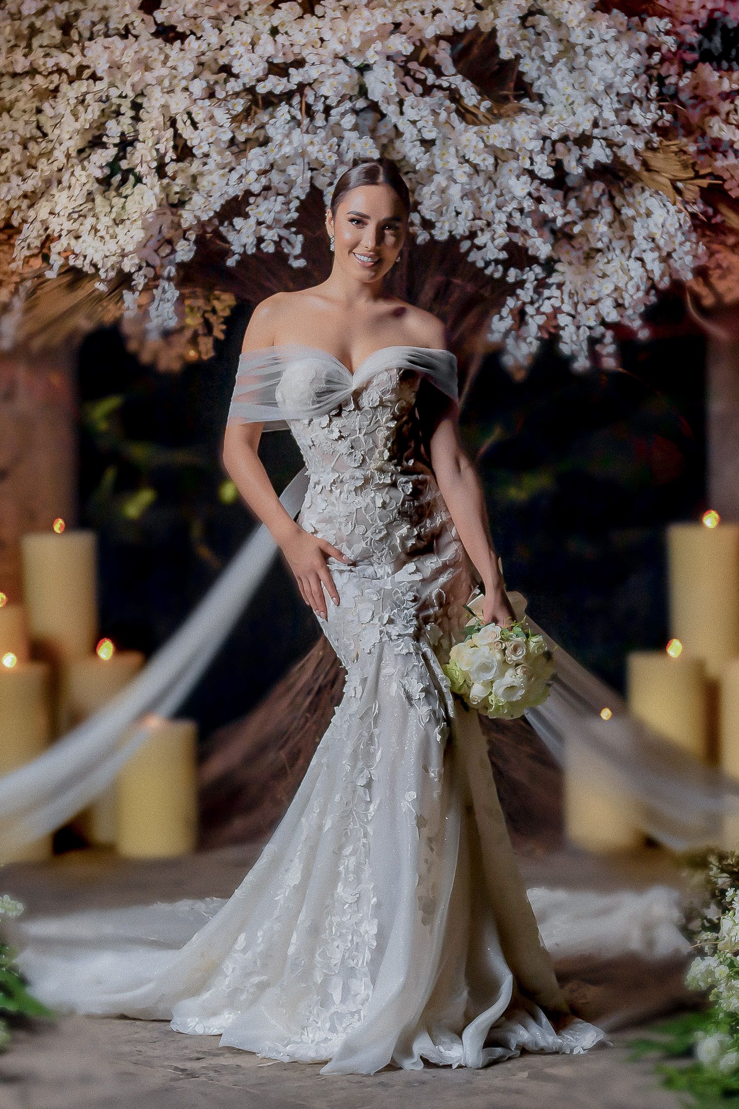 Fitted lace mermaid wedding gown photographed with cherry blossoms and candlelight.