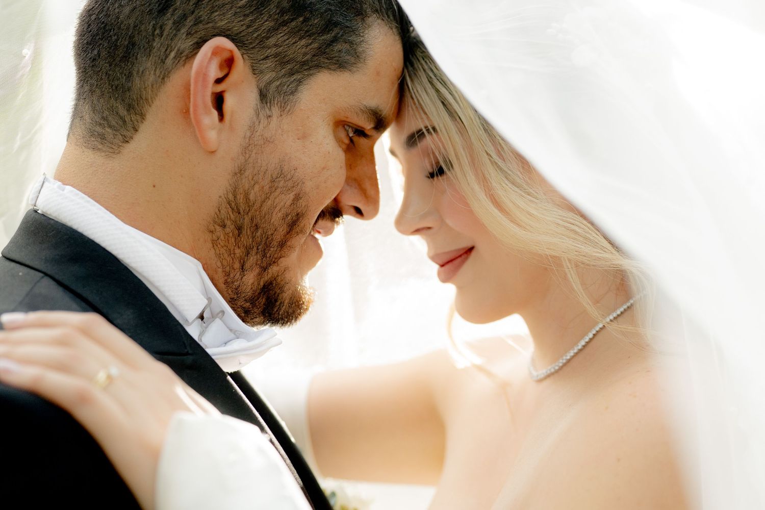 A romantic bride and groom share an intimate forehead touch moment on their wedding day.
