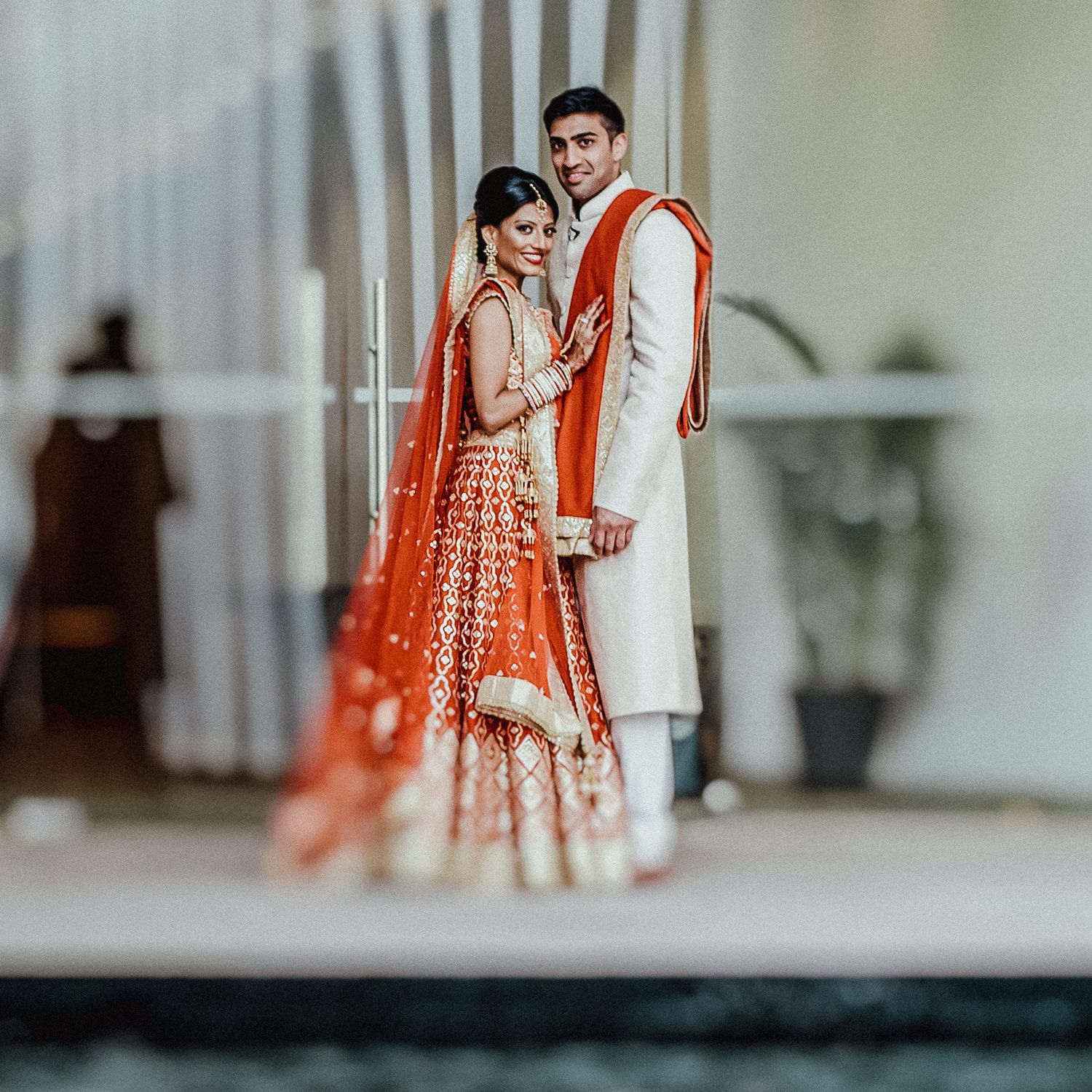 Wedding party posing together in a bright indoor venue with modern decor.