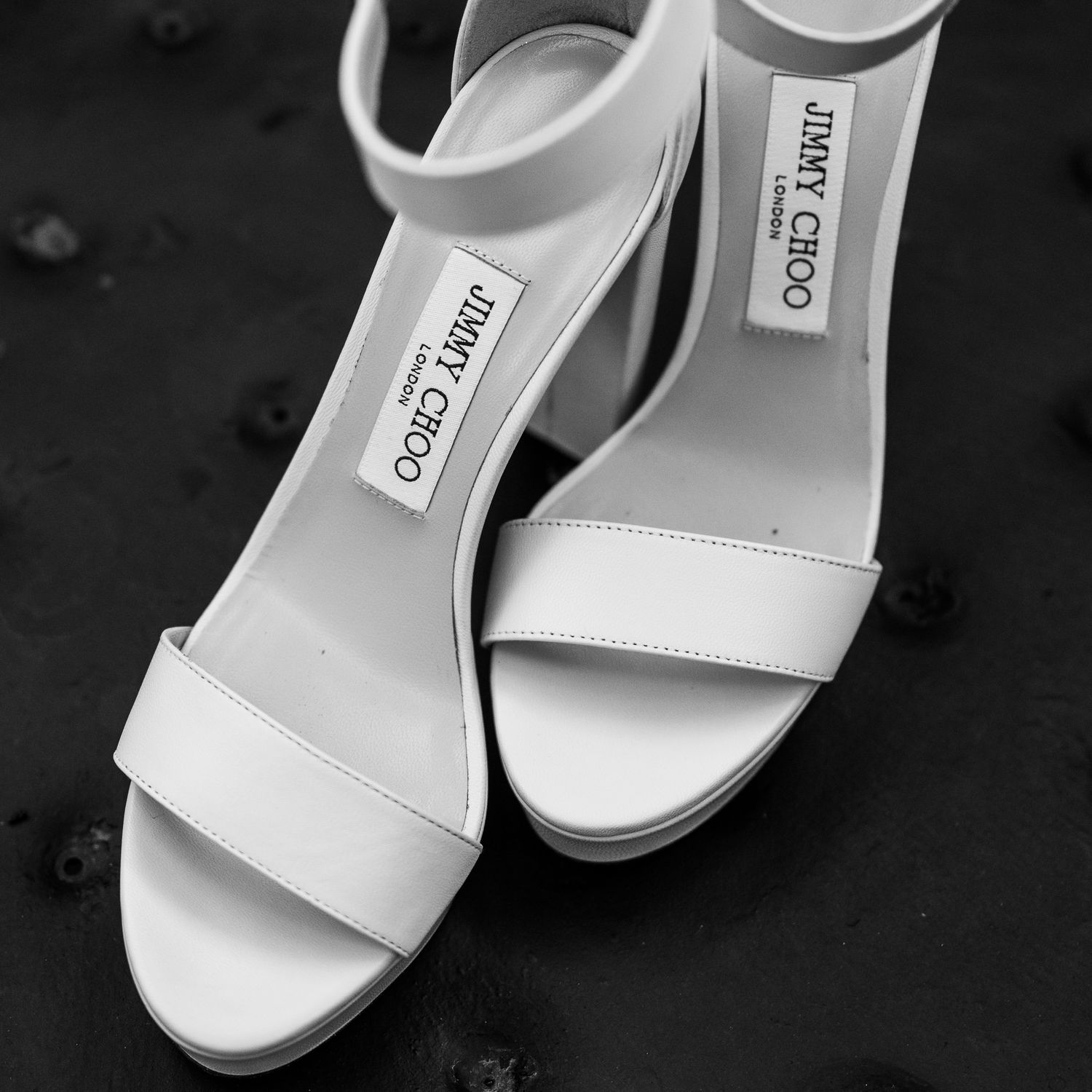 Classic white bridal sandals photographed in black and white.