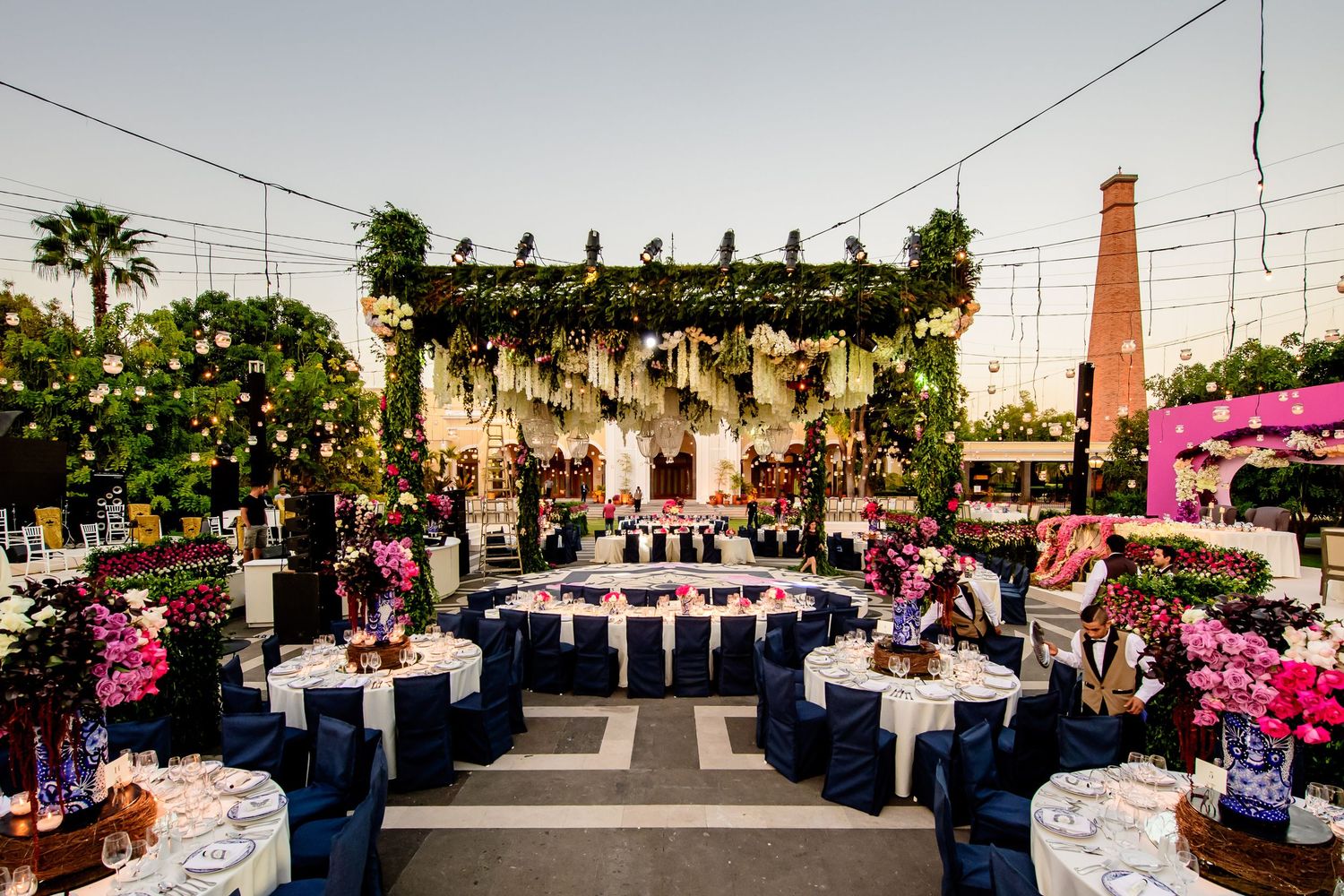 Long banquet tables arranged outdoors for an elegant evening wedding reception.