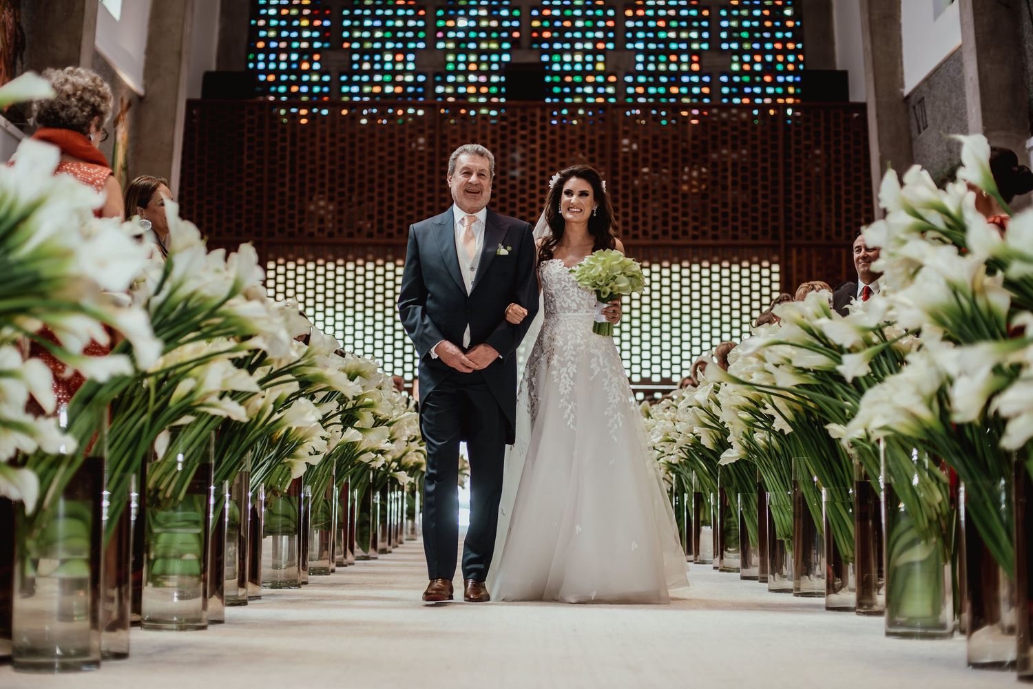 Wedding ceremony aisle decorated with white lilies and greenery.