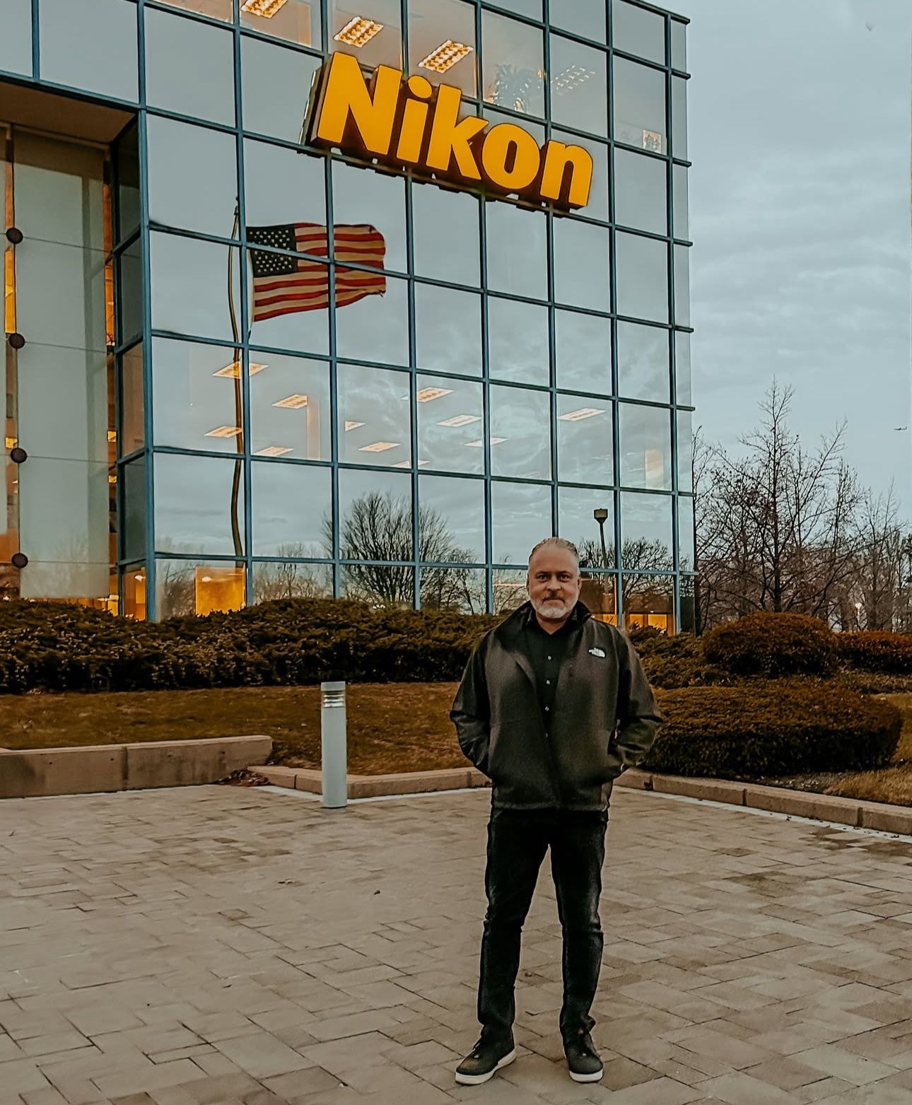 Exterior view of Nikon headquarters building with person standing in front.