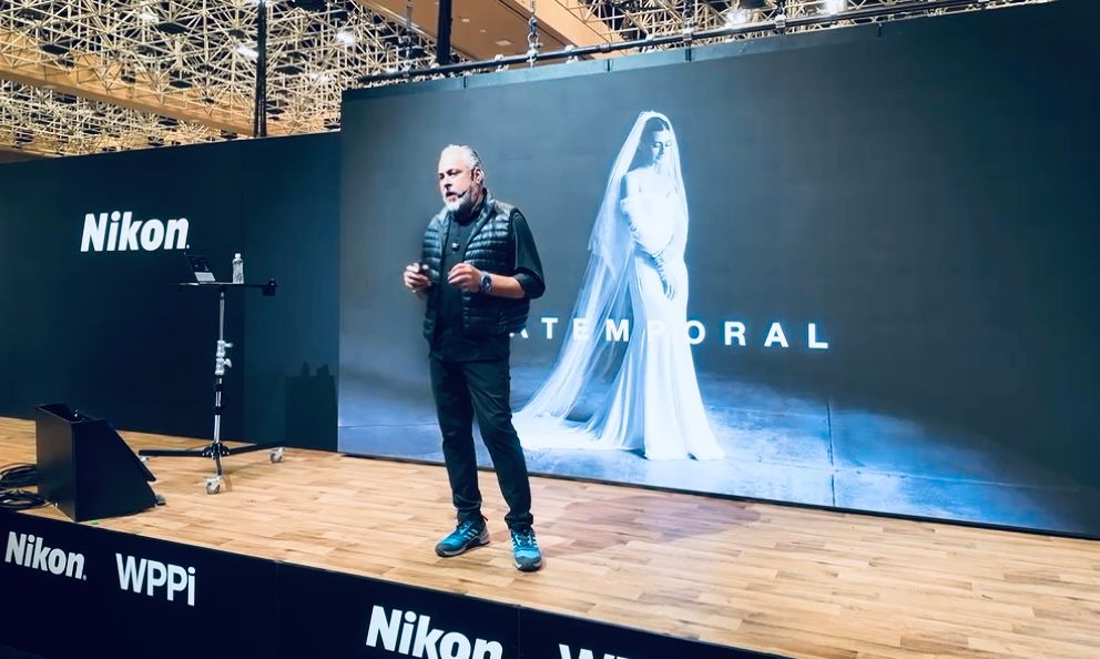 Professional photography presentation setup with large display screens and Nikon branding.