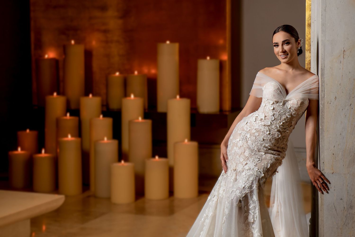 Wedding dress portrait with romantic candlelit backdrop showing delicate lace details.