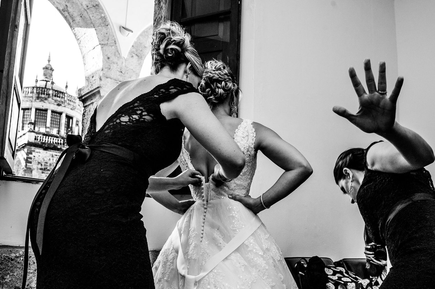 Black and white candid moments of wedding preparation with multiple people.