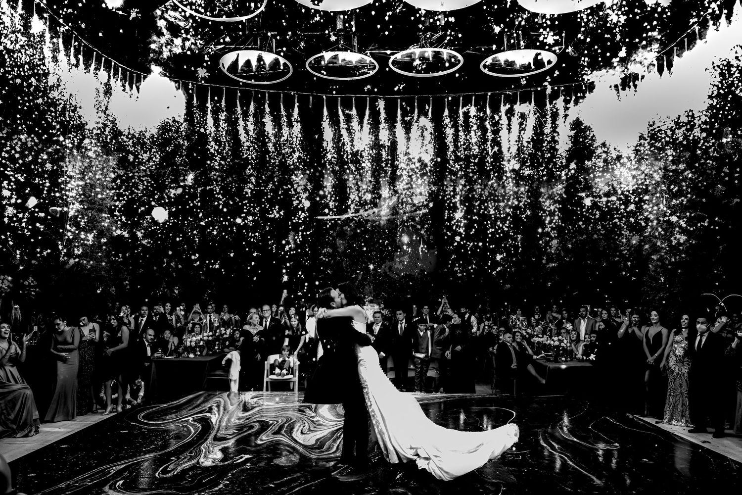Dramatic overhead floral installations with hanging white flowers create an ethereal ceiling design.