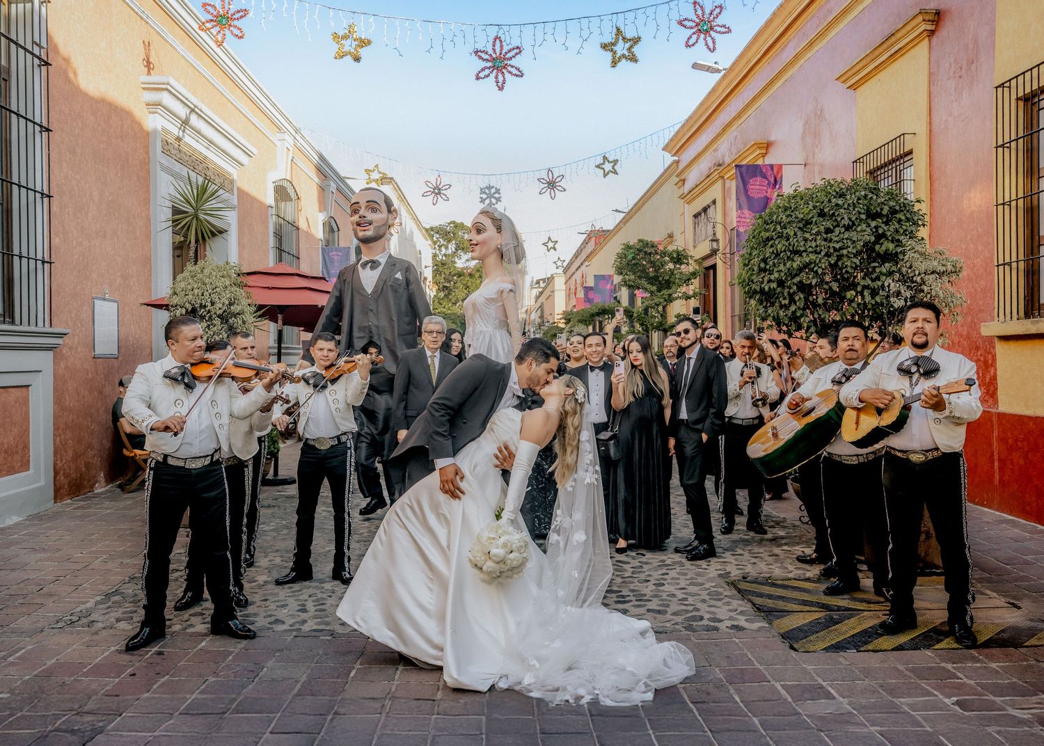 Wedding guests line a colorful Mexican street as a couple celebrates their special day in Puebla.