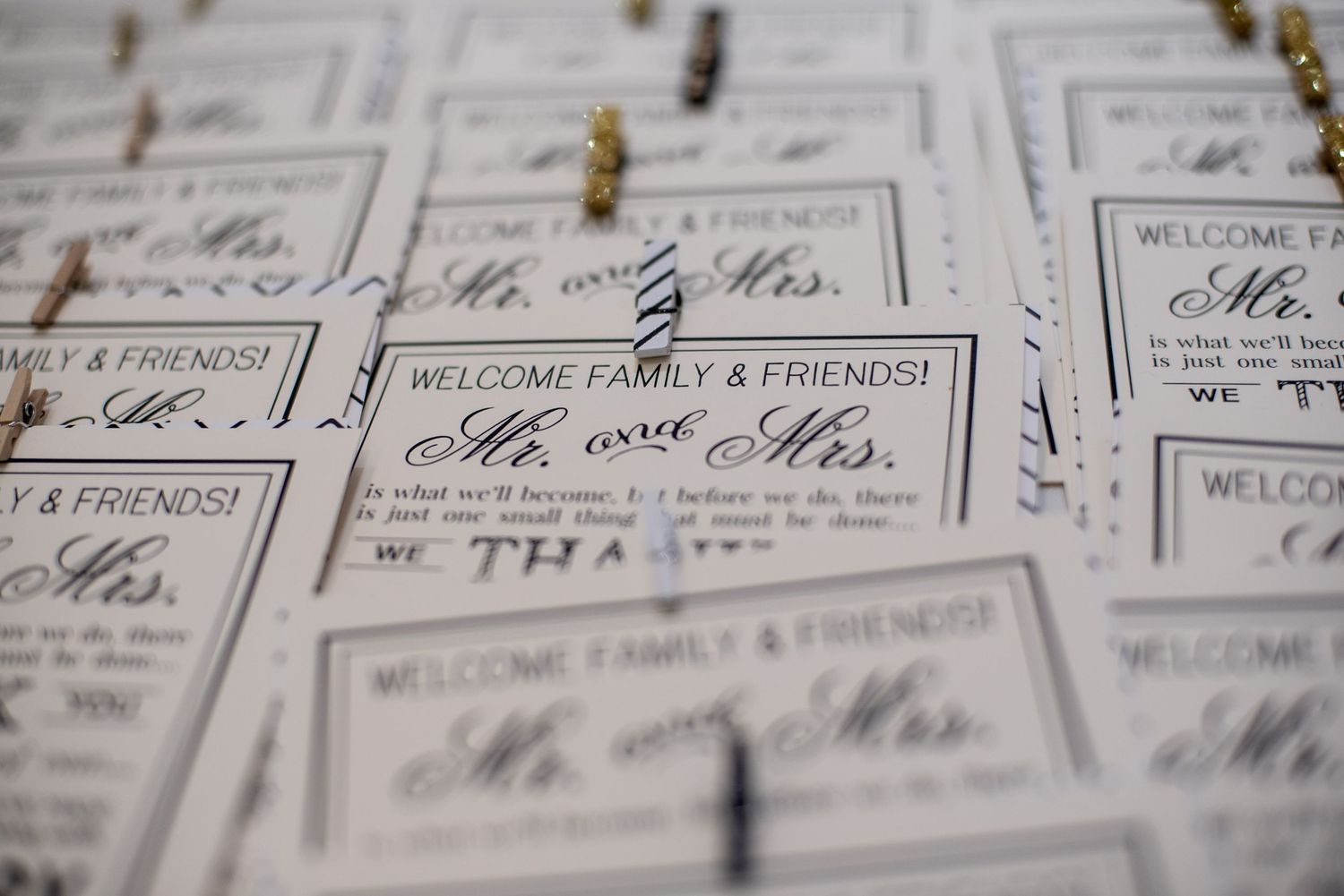 Wedding welcome cards for family and friends addressing Mr. and Mrs. displayed on a table at a reception.