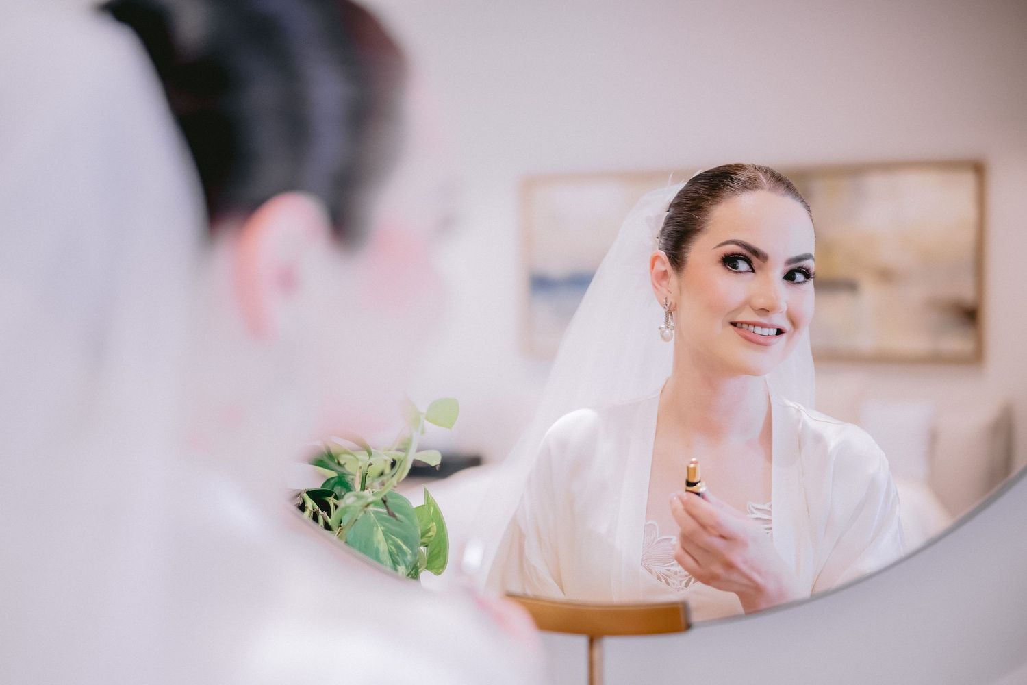 Soft focus images of a bride in white robe during morning wedding preparations.