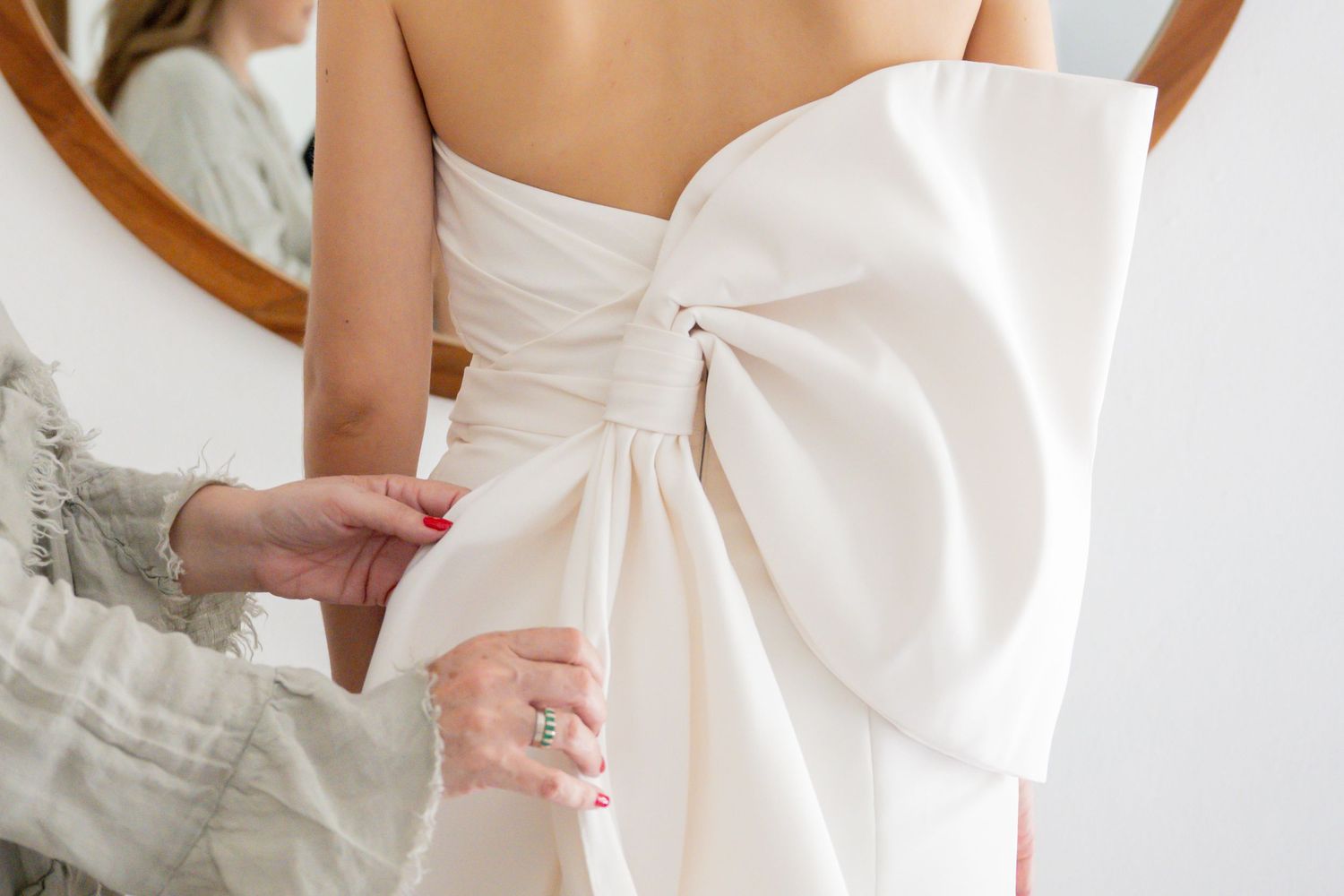 Back detail of white wedding dress showing elegant bow design.