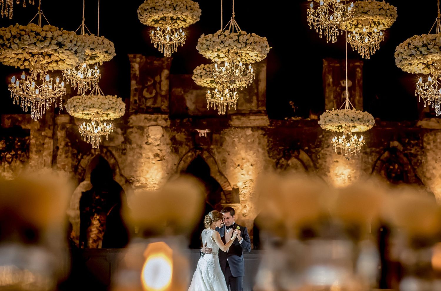 Elegant ballroom reception with crystal chandeliers and warm ambient lighting.