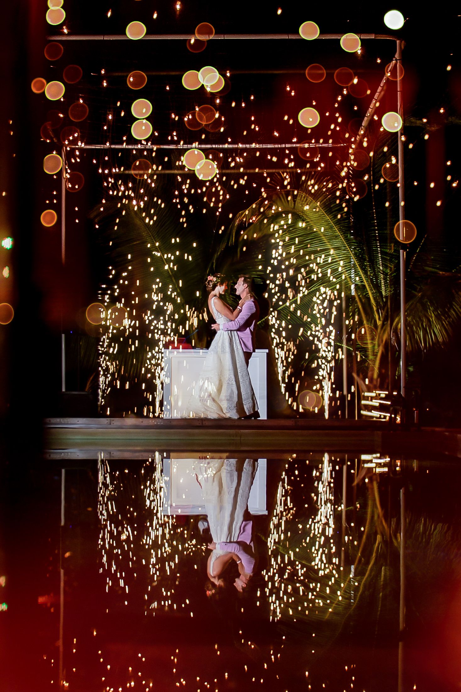 Romantic wedding dance under twinkling lights and sparklers creating a magical atmosphere.