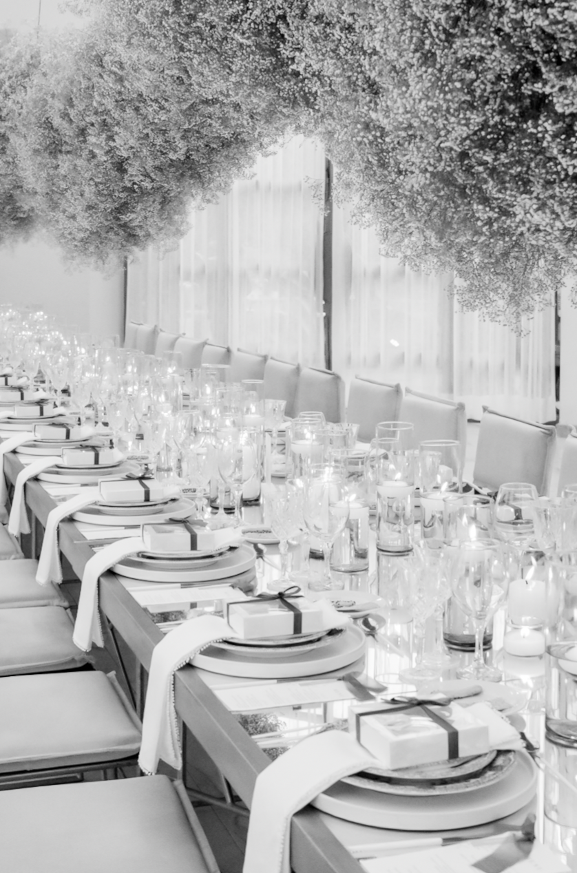 Elegant wedding reception table setting with glassware and place settings in black and white.
