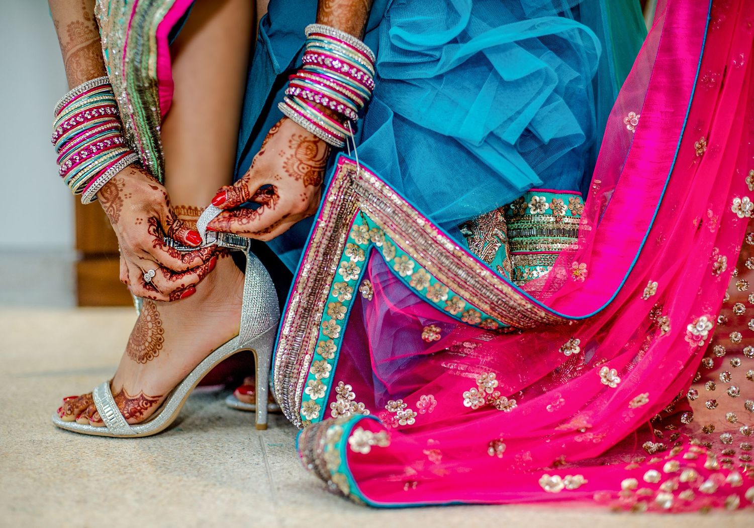 Colorful Indian wedding attire details showing bangles and embroidered fabric.