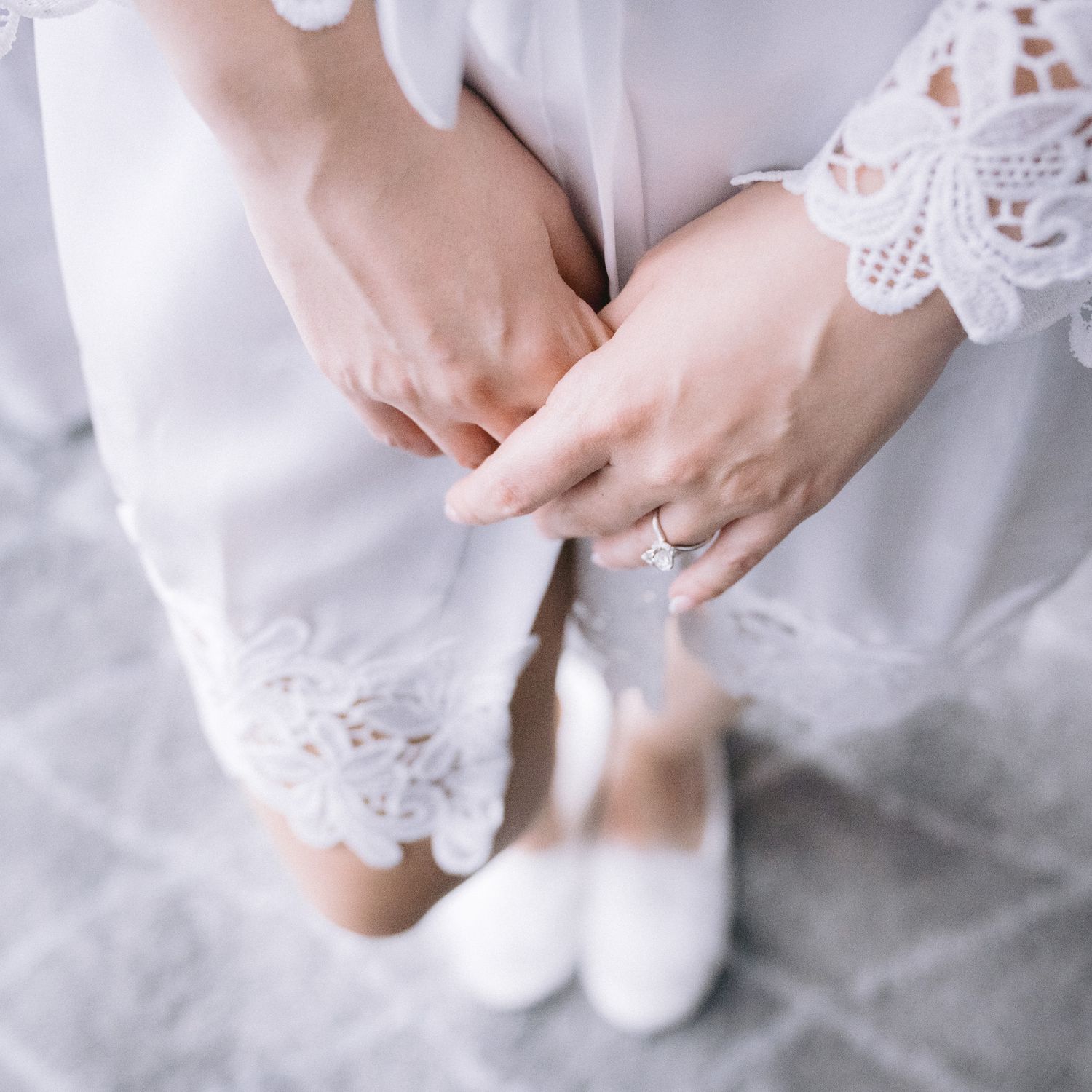 Detail shots of lace wedding dress and hands with wedding ring.