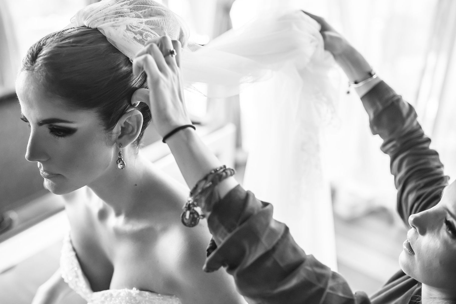 Black and white sequence showing final adjustments being made to a wedding dress.