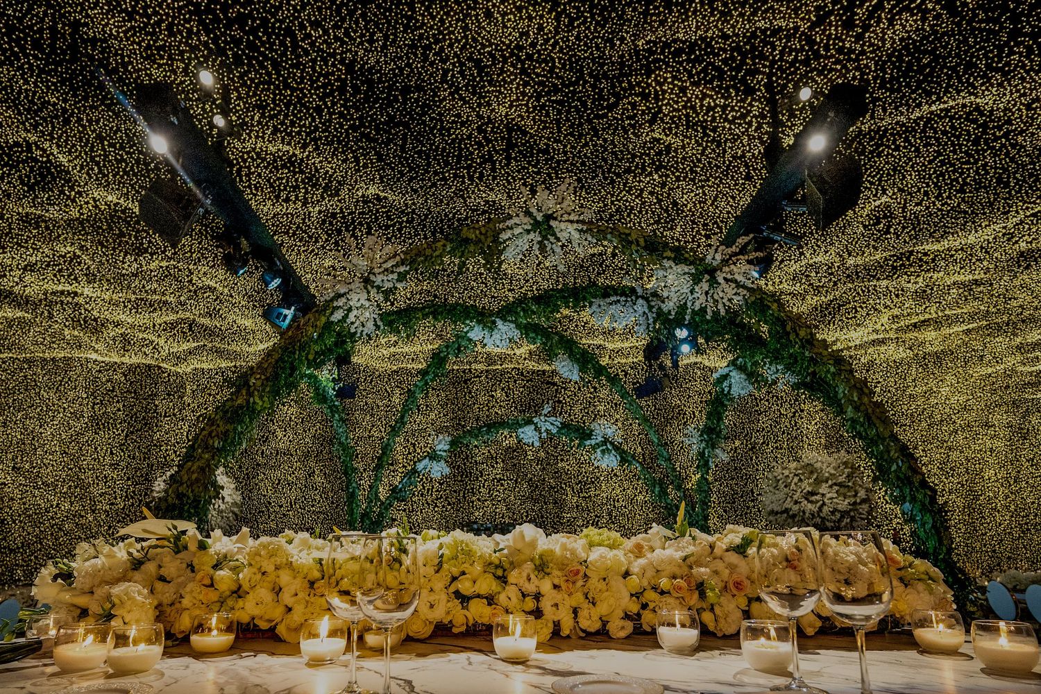 Wedding venue ceiling adorned with twinkling lights and hanging decorations creating a starry effect.