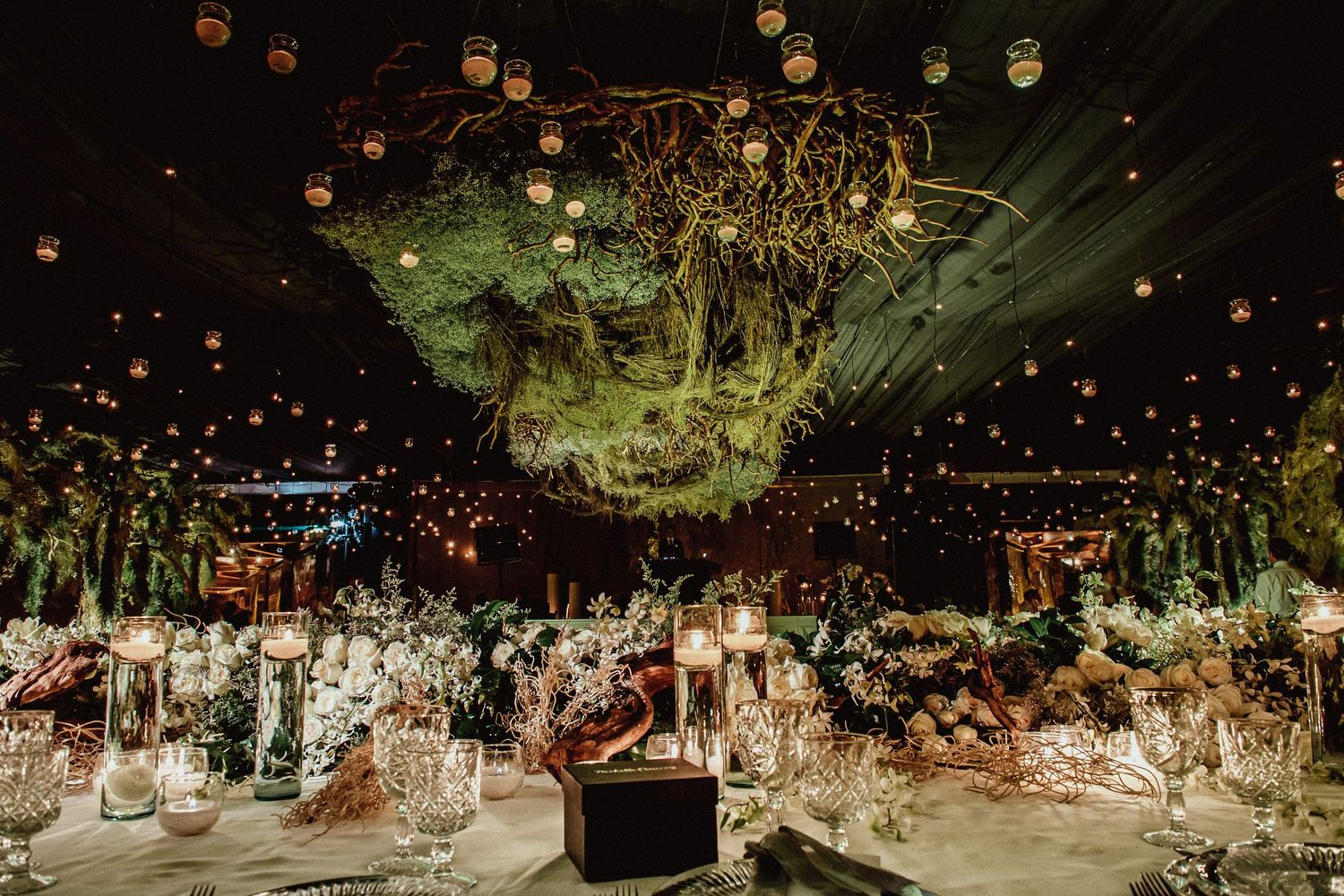 Ethereal wedding decor featuring suspended greenery and twinkling lights creating a magical canopy.