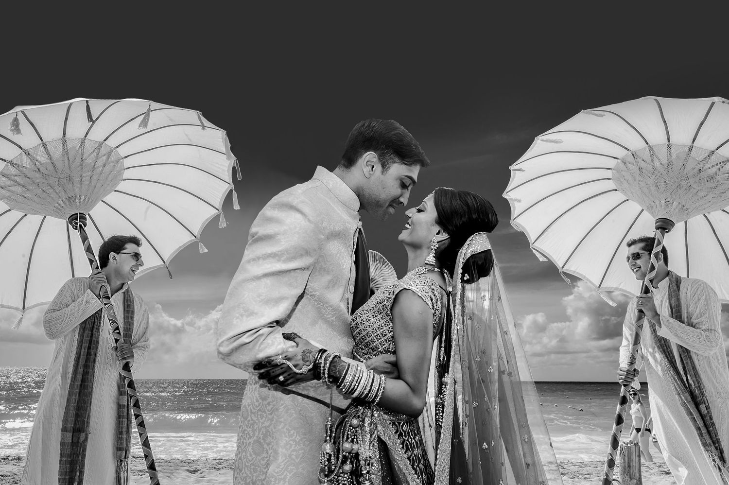 Wedding party holding white parasols in black and white photography.