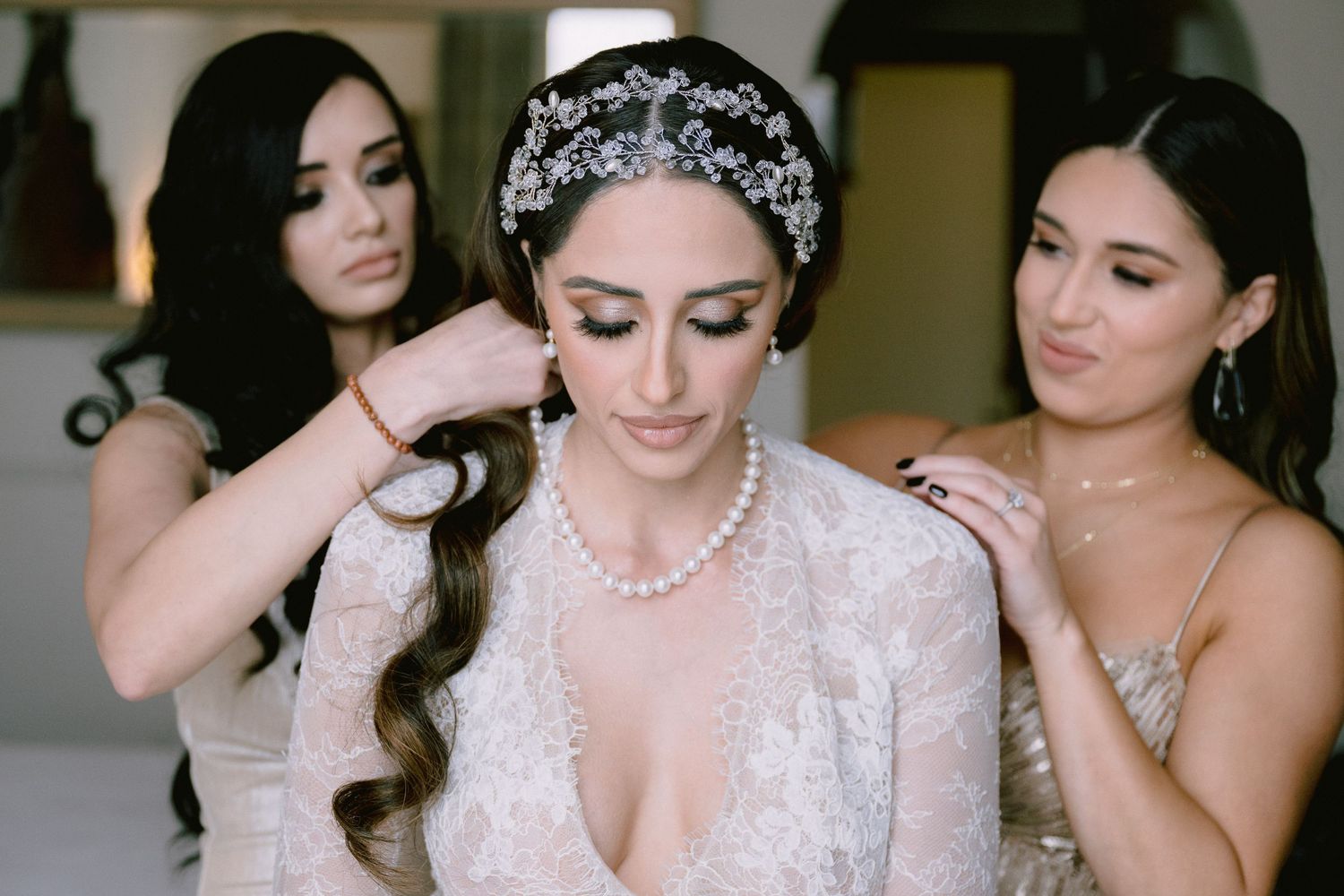Wedding preparation scene with ornate crystal headpiece and pearl jewelry.