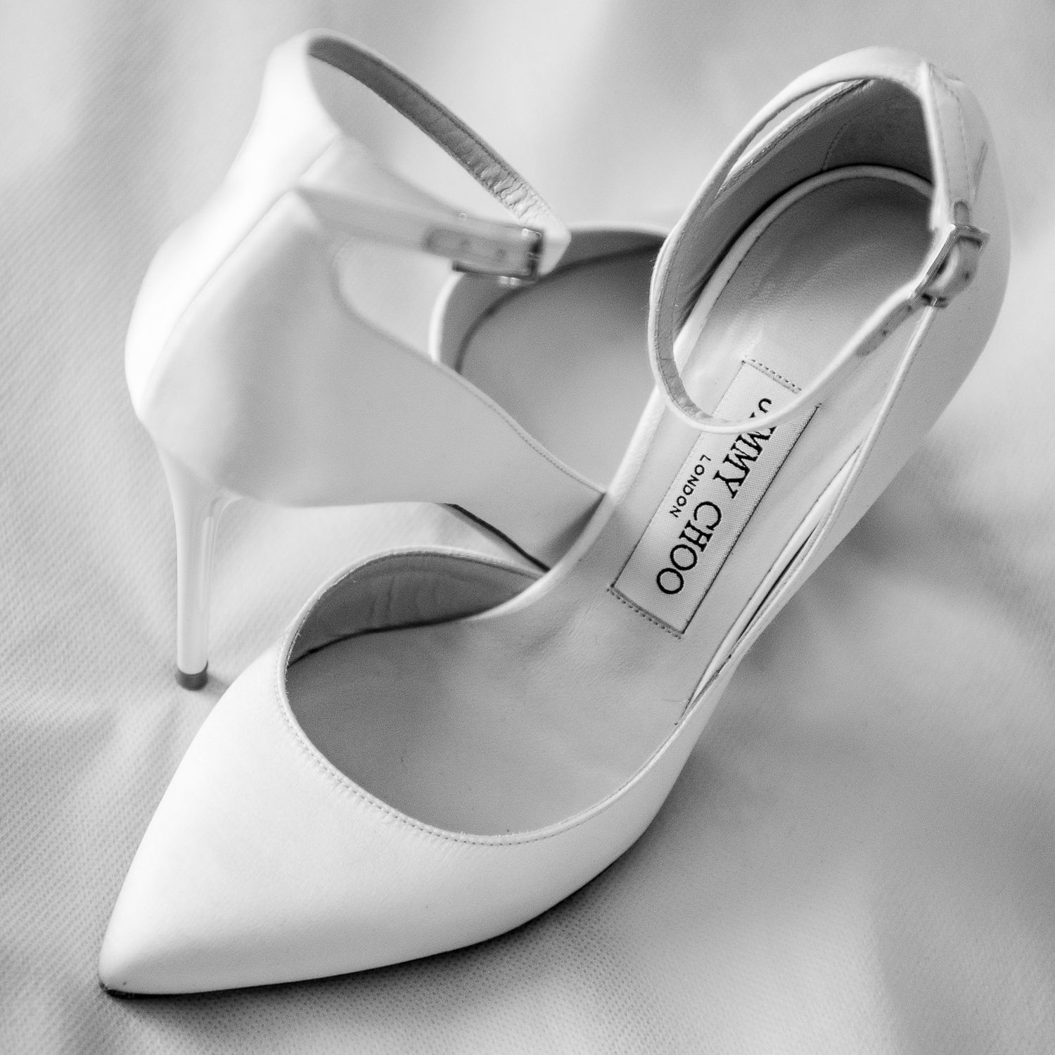 Minimalist white bridal shoes photographed from multiple angles in soft light.