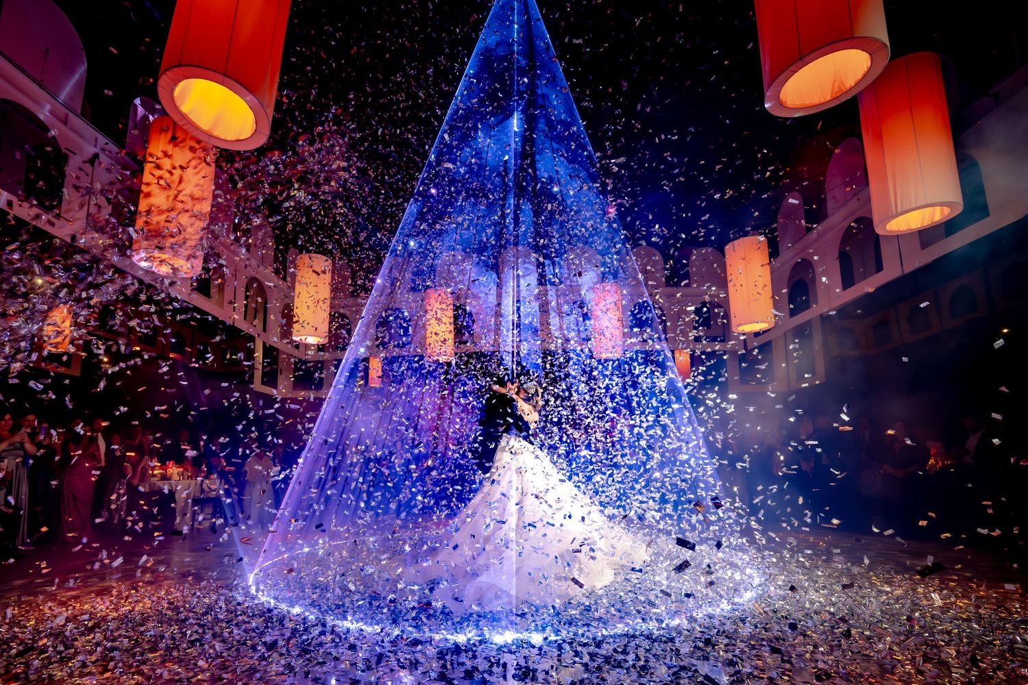 A stunning blue illuminated wedding display with floating lanterns and confetti creates a magical atmosphere.