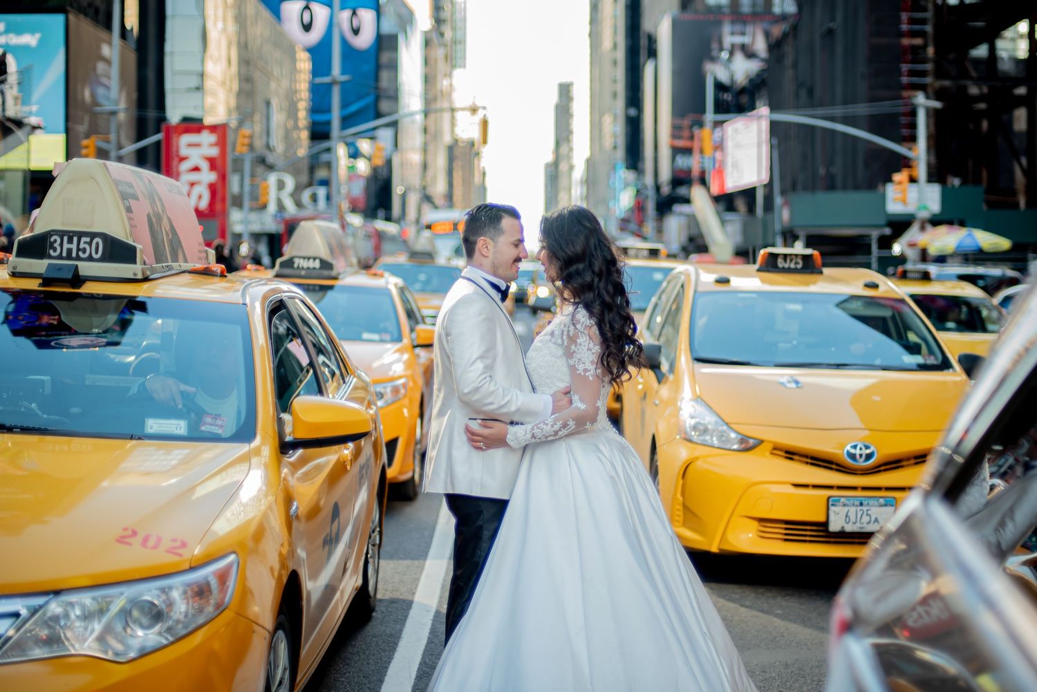 Wedding couple posing on city street with iconic yellow NYC taxis in background.