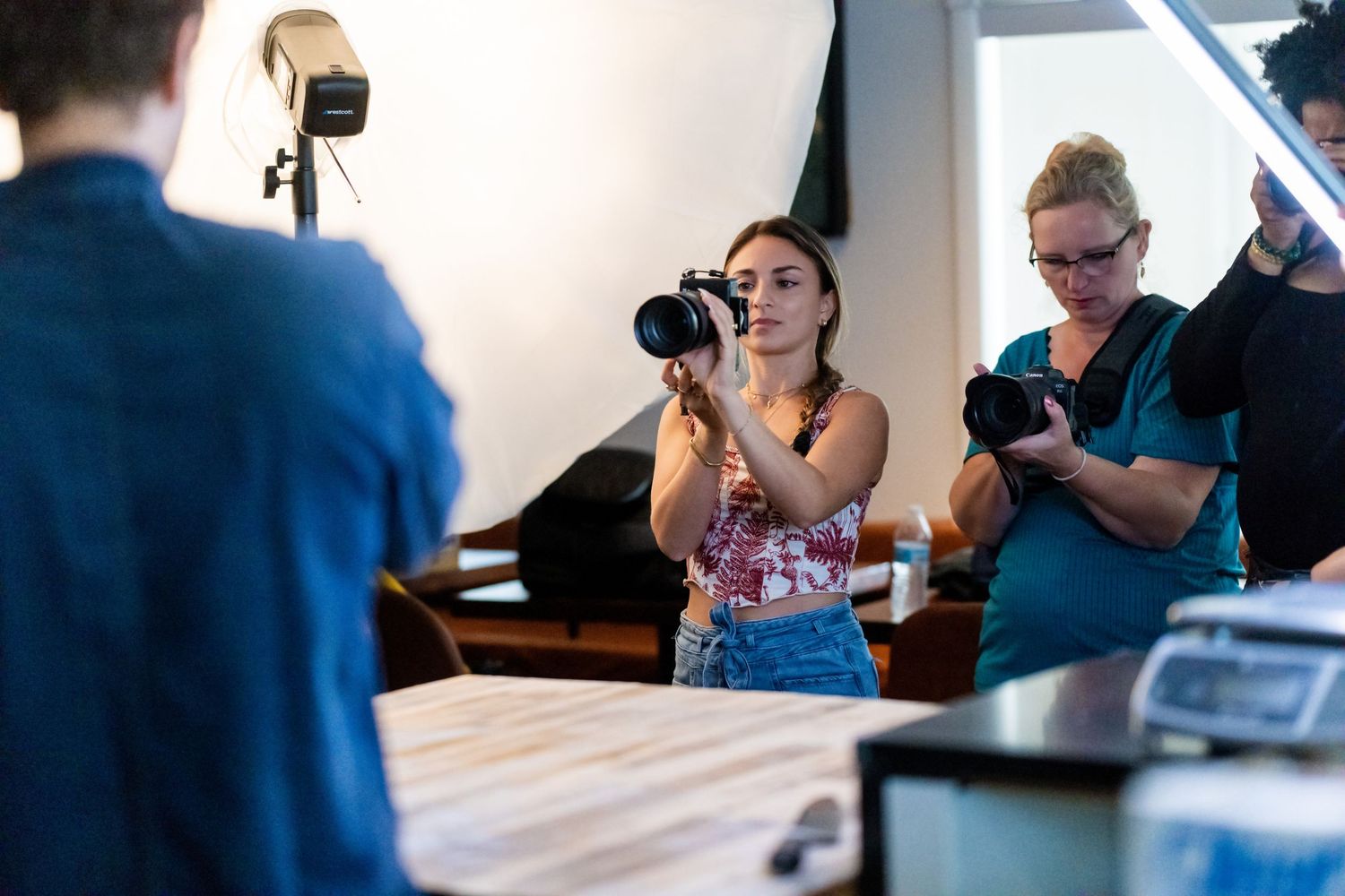 Behind the scenes view of photography session with cameras and equipment indoors.