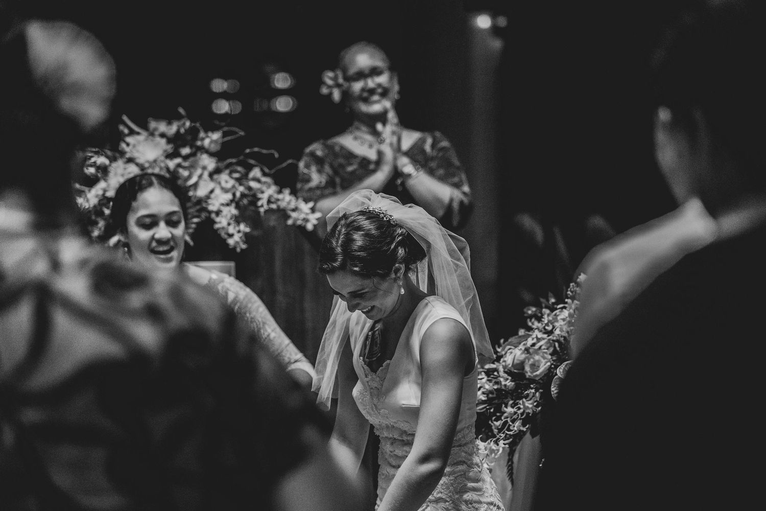 A joyful black and white wedding ceremony moment captured with guests and floral decorations in an intimate setting.