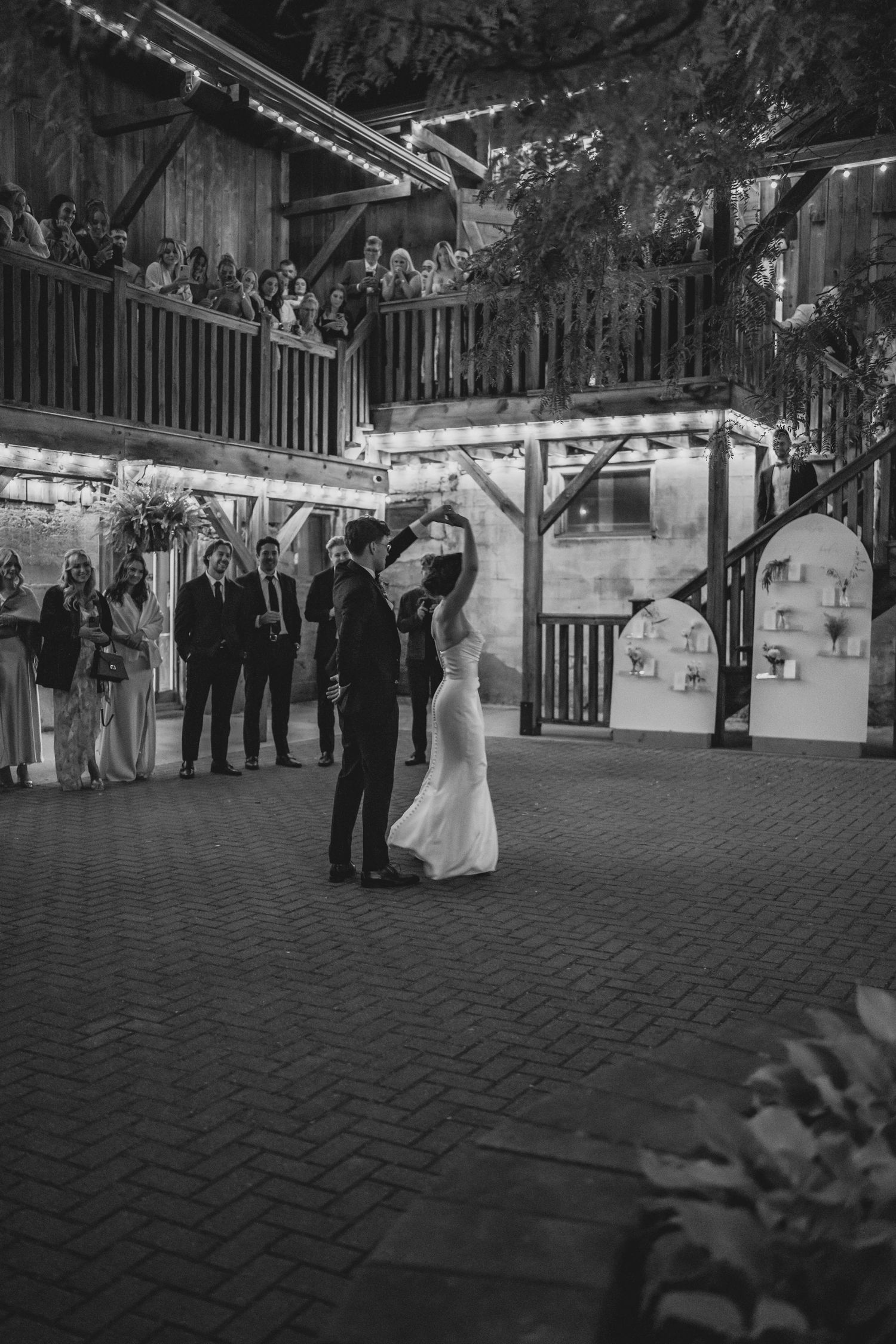 A sequence of black and white photos showing guests gathered at an outdoor wedding reception under a covered pavilion.