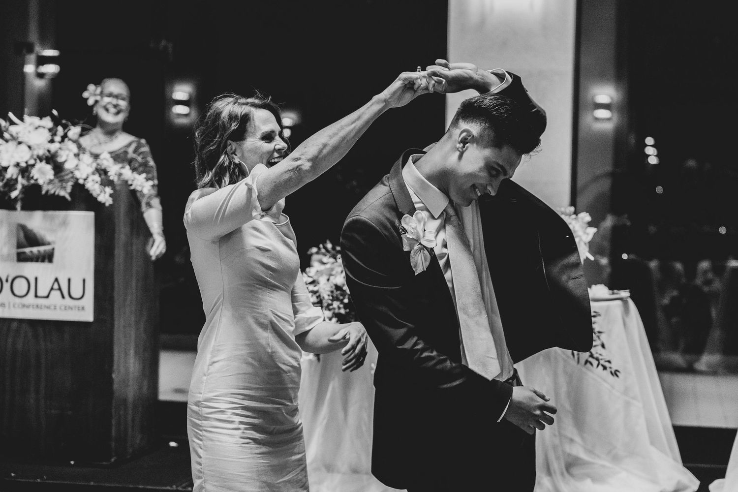 A couple shares an intimate dance moment during their wedding celebration in black and white photography.